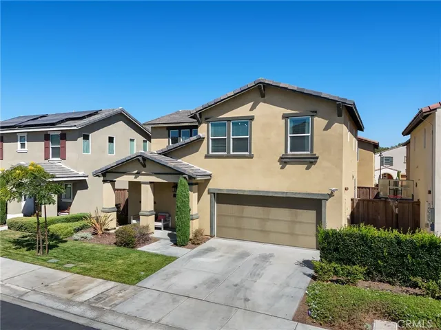 a front view of a house with a yard and potted plants