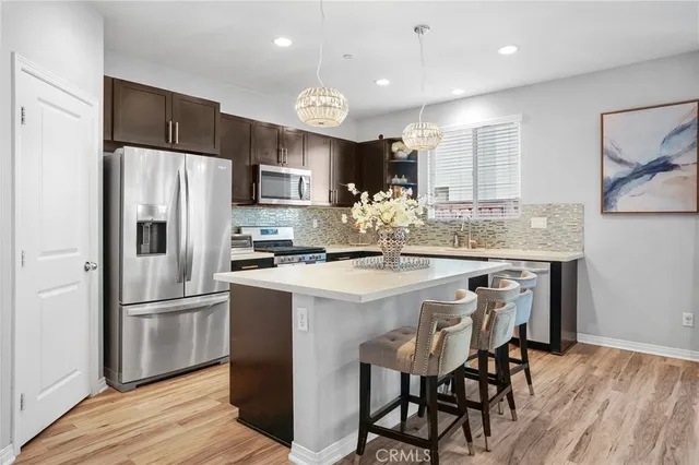 a kitchen with kitchen island granite countertop a refrigerator and a stove top oven