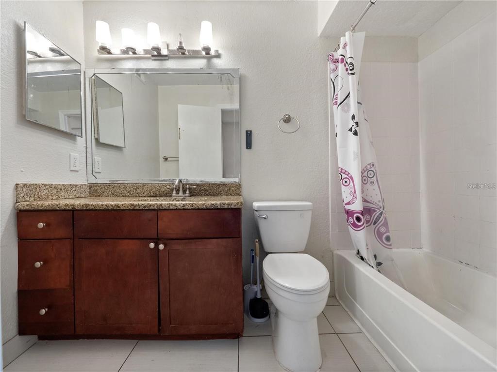 5144 Conroy Road, Unit 27 Orlando, FL 32811 - Photo 15 of 20 a bathroom with a granite countertop toilet sink and mirror
