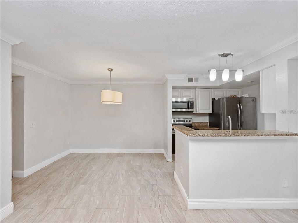5144 Conroy Road, Unit 27 Orlando, FL 32811 - Photo 5 of 20 a view of a kitchen with a sink dishwasher a refrigerator and cabinets