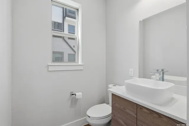 a bathroom with a sink a toilet and a mirror