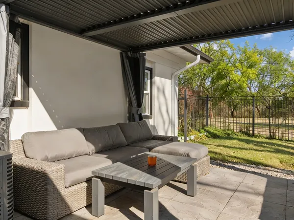 a view of a chair and table in backyard of the house