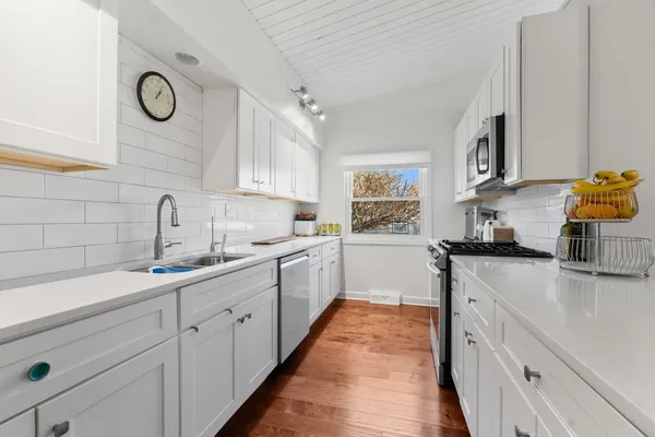 a kitchen with stainless steel appliances granite countertop a stove a sink and a microwave