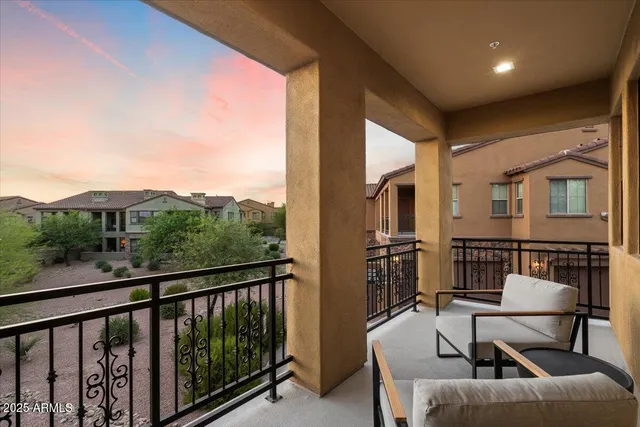a view of a room with a hanging light and kitchen view