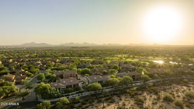 a kitchen with stainless steel appliances granite countertop a refrigerator a sink dishwasher a dining table and chairs with wooden floor