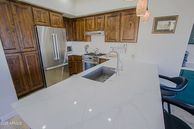 a kitchen with stainless steel appliances granite countertop a sink stove and cabinets