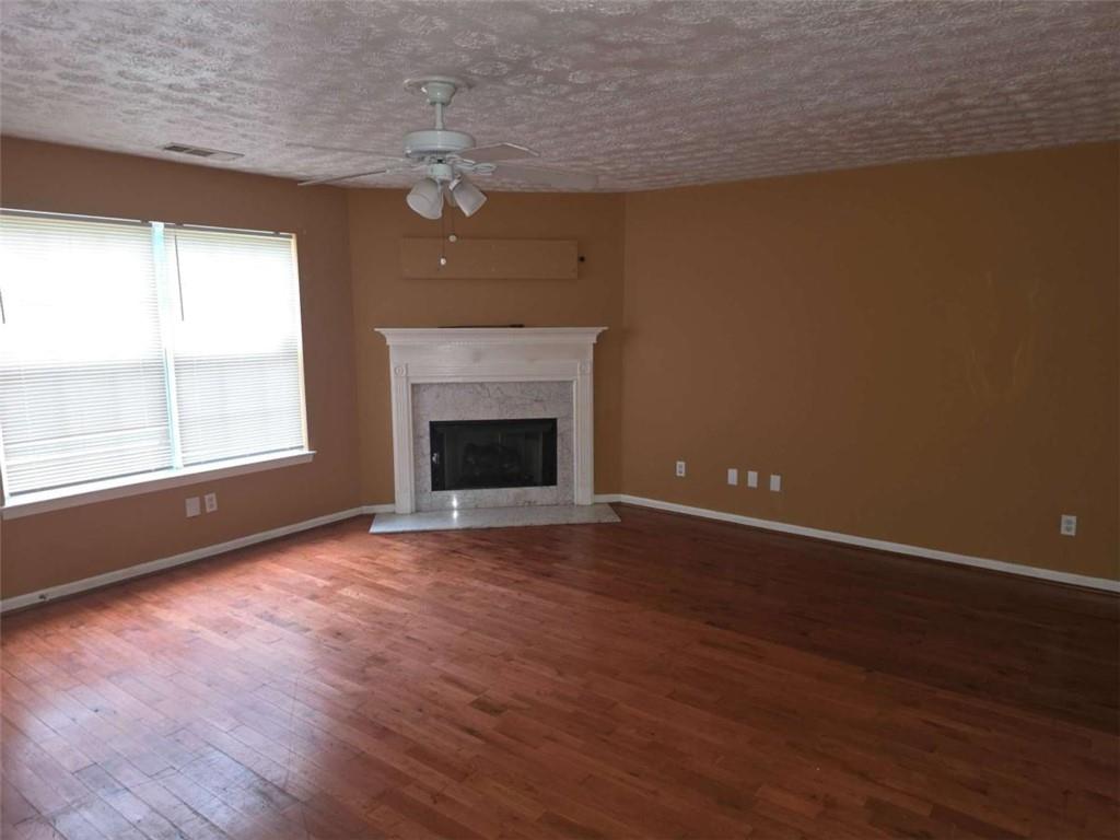 4410 Cross Lane Decatur, GA 30035 - Photo 4 of 26 an empty room with wooden floor fireplace and windows