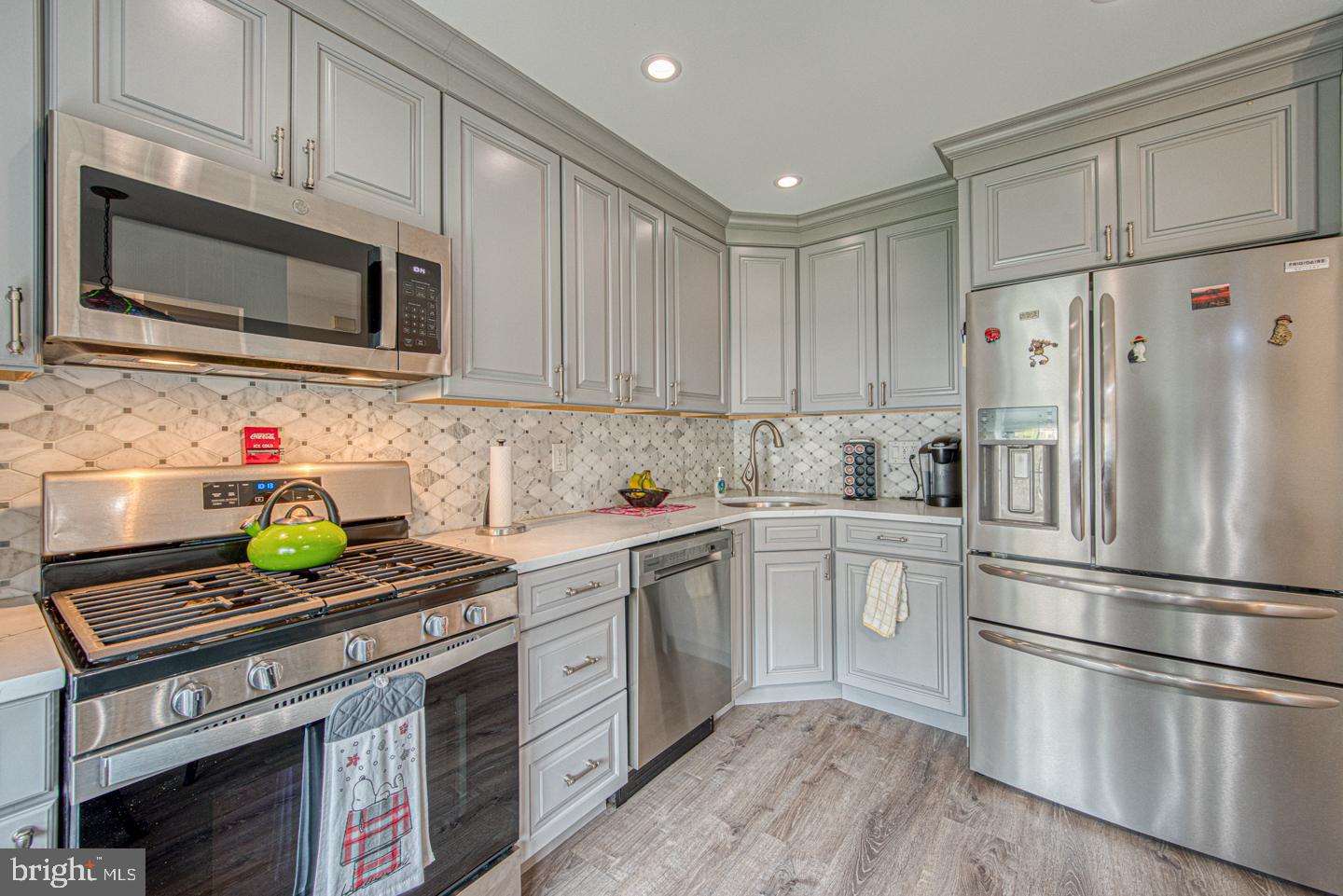 333 Scola Road Brookhaven, PA 19015 - Photo 11 of 57 a kitchen with stainless steel appliances white cabinets and a stove top oven
