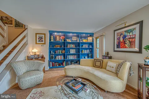 a living room with furniture and a book shelf