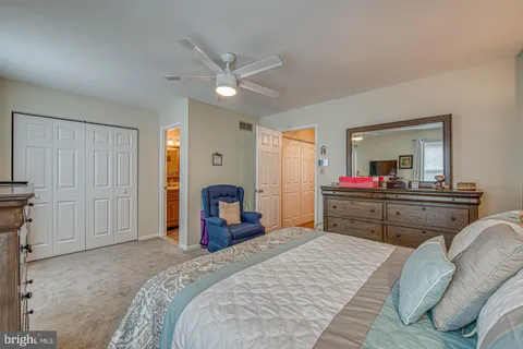 a bedroom with a bed and dresser with mirror