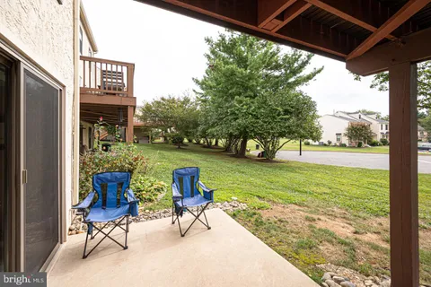 a balcony with wooden floor table and chairs