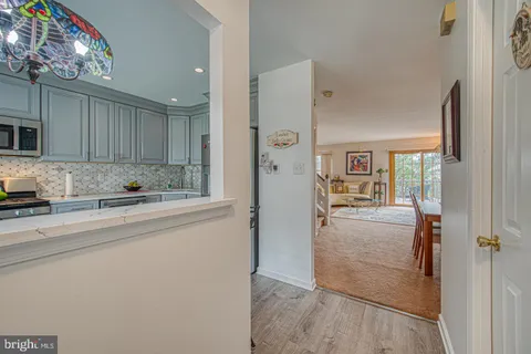 a kitchen with a table chairs microwave and cabinets