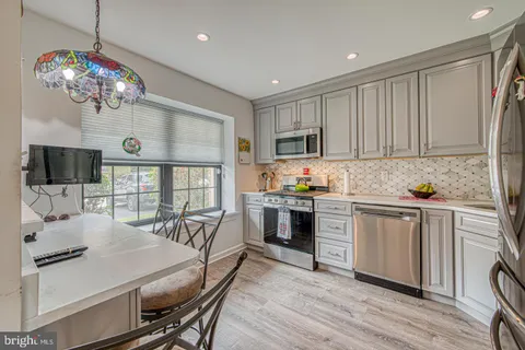 a kitchen with stainless steel appliances granite countertop a sink a stove and cabinets