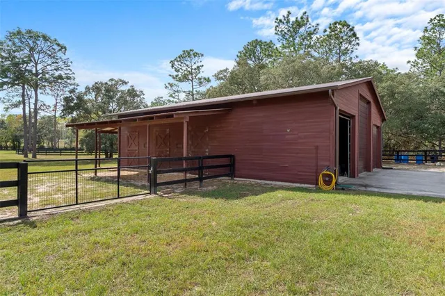 an aerial view of residential houses with outdoor space and trees