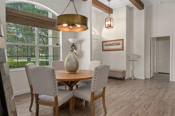 a large kitchen with granite countertop a stove a sink a dining table and chairs with wooden floor