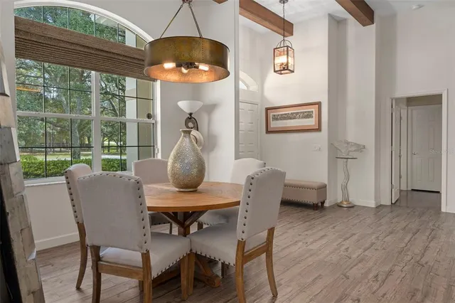 a large kitchen with granite countertop a stove a sink a dining table and chairs with wooden floor