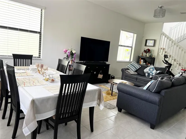 a living room with furniture a flat screen tv and a large window
