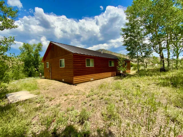 a view of house with yard and trampoline