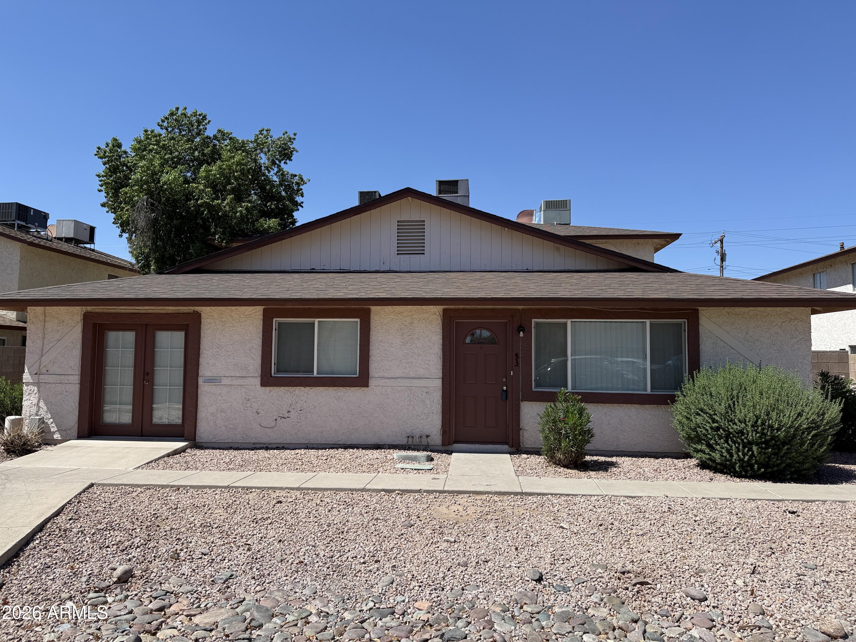860 East Brown Road, Unit 53 Mesa, AZ 85203 - Photo 1 of 14 a front view of a house with a yard and garage