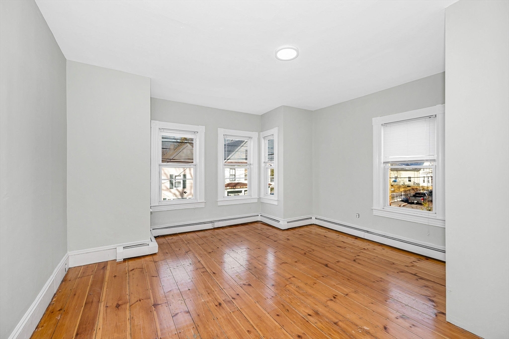 339 Lincoln Street, Unit 2 Lowell, MA 01852 - Photo 11 of 18 an empty room with wooden floor and windows