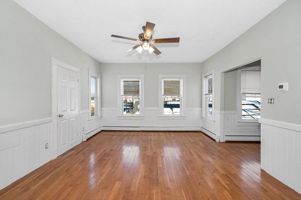 339 Lincoln Street, Unit 2 Lowell, MA 01852 - Photo 6 of 18 a view of empty room with wooden floor and fan