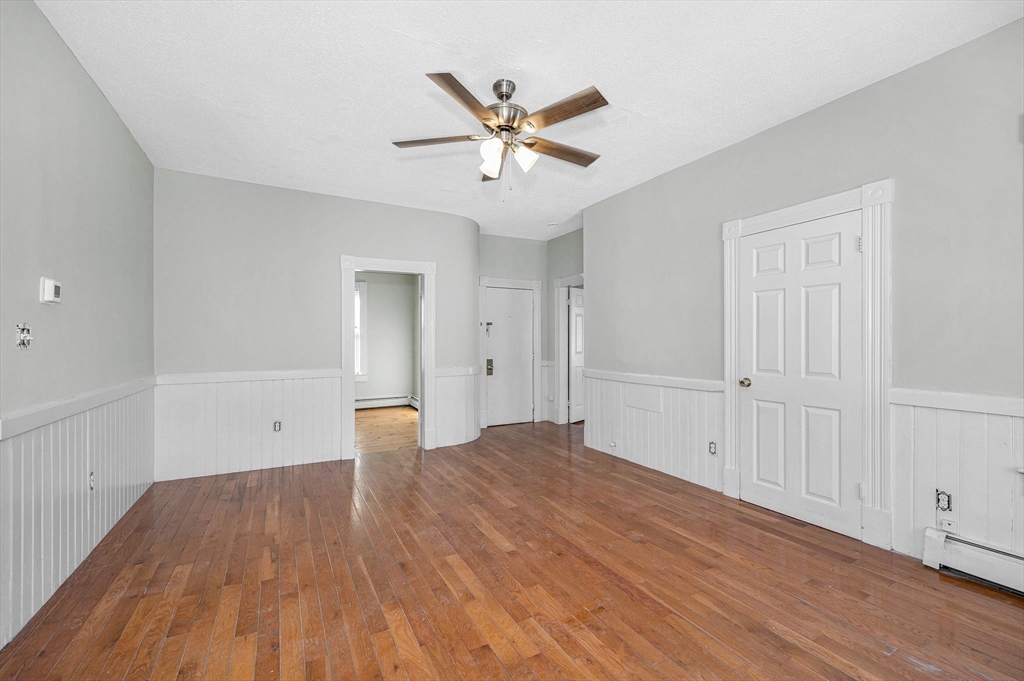 339 Lincoln Street, Unit 2 Lowell, MA 01852 - Photo 7 of 18 wooden floor in an empty room with a window
