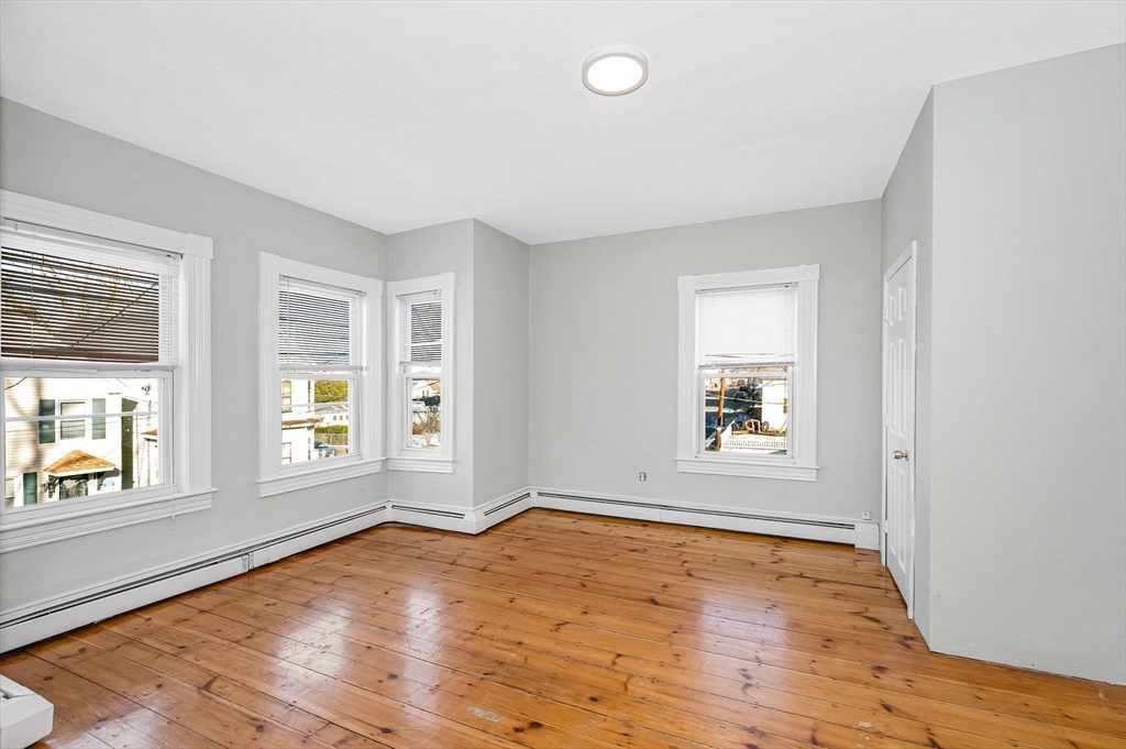 339 Lincoln Street, Unit 2 Lowell, MA 01852 - Photo 8 of 18 an empty room with wooden floor and windows