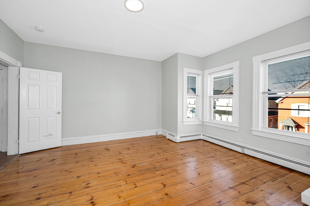 339 Lincoln Street, Unit 2 Lowell, MA 01852 - Photo 10 of 18 a view of an empty room with wooden floor and a window
