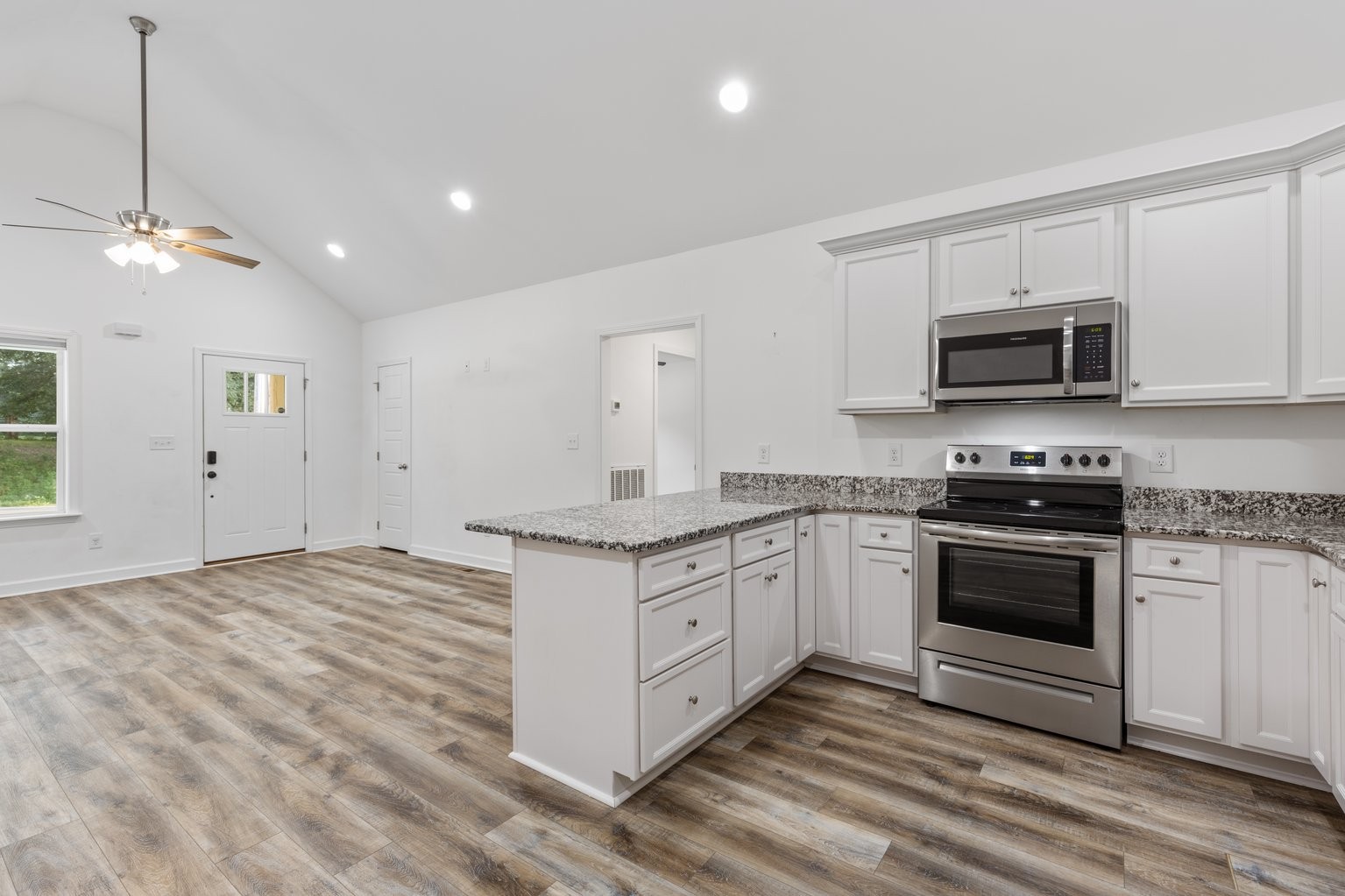 10580 Church Road Bon Aqua, TN 37025 - Photo 9 of 29 a kitchen with granite countertop a stove a sink and a microwave