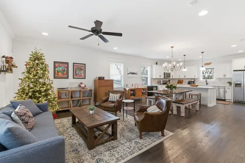 a kitchen with a dining table chairs wooden floor and a view of kitchen
