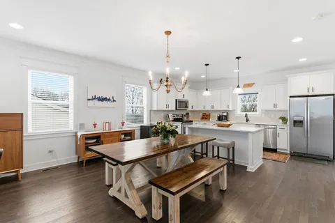 a open dining room with kitchen island stainless steel appliances furniture a chandelier and kitchen view