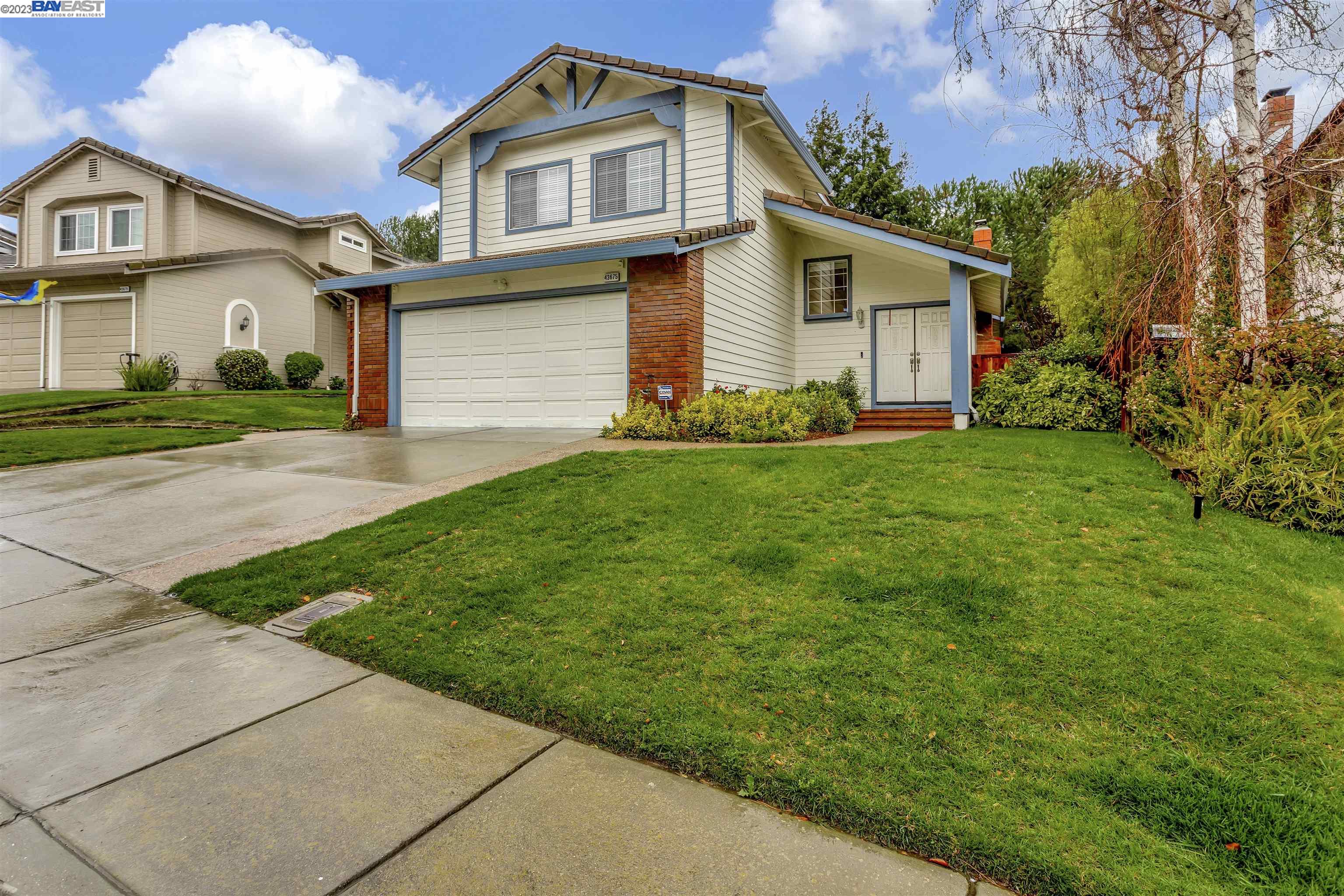 a front view of a house with a garden and yard