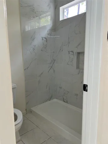 a bath room with a toilet and a bath tub