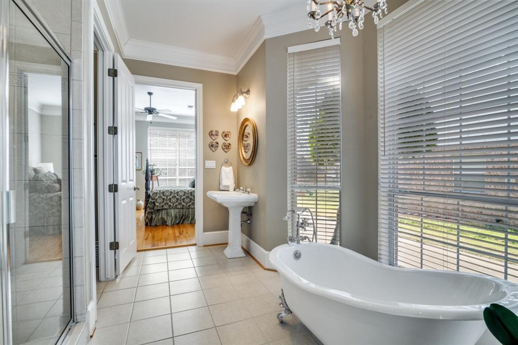 8 Griffith Court Terrell, TX 75160 - Photo 14 of 25 Full connected bathroom, ornamental molding, a shower stall, light tile floors, and a freestanding tub