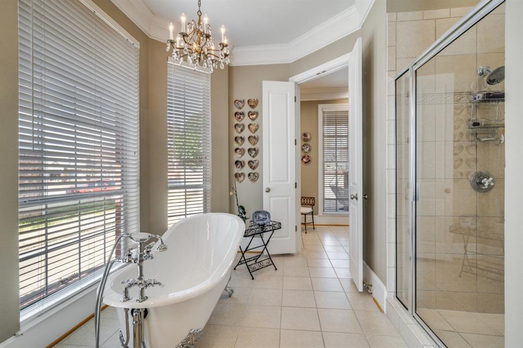 8 Griffith Court Terrell, TX 75160 - Photo 15 of 25 Bathroom featuring crown molding, a shower stall, a freestanding bath, hanging lights, and light tile flooring