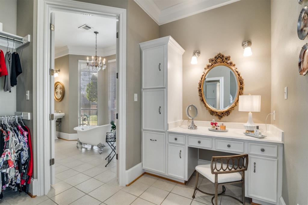 8 Griffith Court Terrell, TX 75160 - Photo 16 of 25 Bathroom with crown molding, double vanities, a freestanding tub, suspended lighting, and a spacious closet