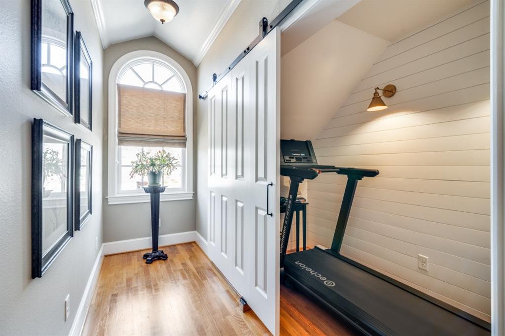 8 Griffith Court Terrell, TX 75160 - Photo 19 of 25 Exercise room featuring a barn door, ornamental molding, light wood-type flooring, and lofted ceiling located in upstairs bedroom