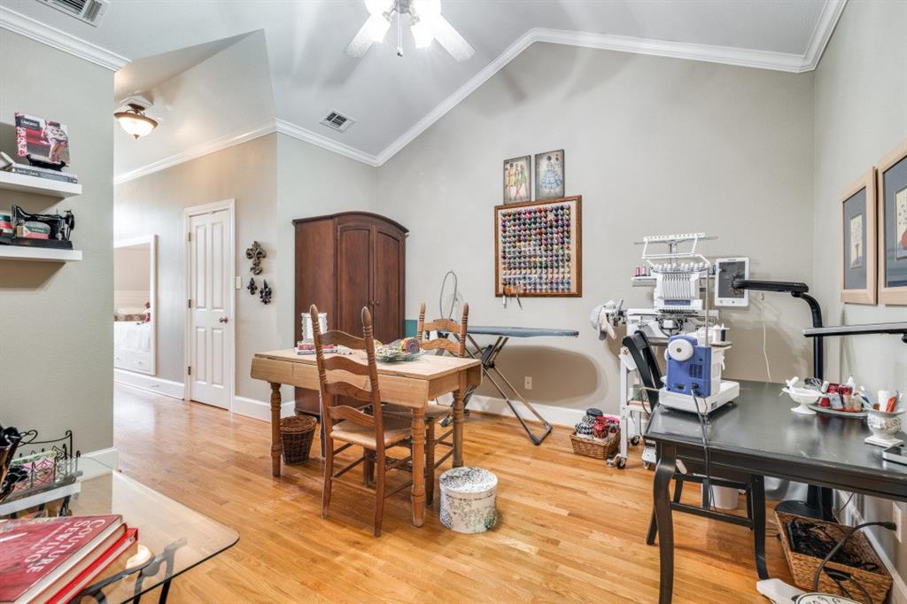 8 Griffith Court Terrell, TX 75160 - Photo 21 of 25 Bedroom with ornamental molding, light hardwood finished floors, lofted ceiling, a ceiling fan, and double built-in twin beds. Large open space could be used for gameroom, media room, or additional living space.