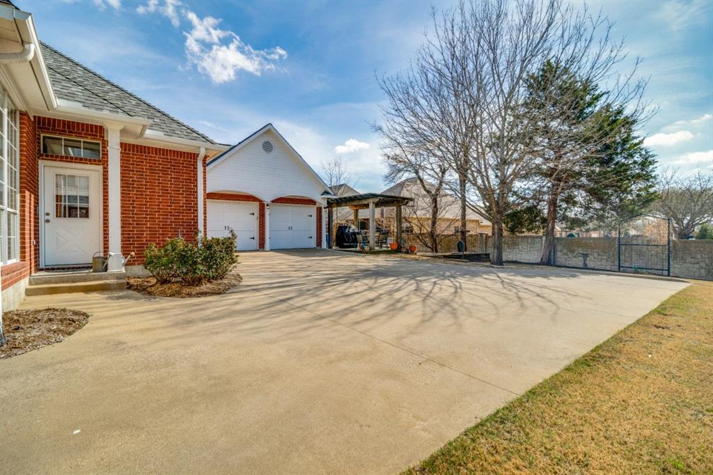 8 Griffith Court Terrell, TX 75160 - Photo 24 of 25 View of backside of home with concrete driveway, an attached garage, brick siding, and a shingled roof