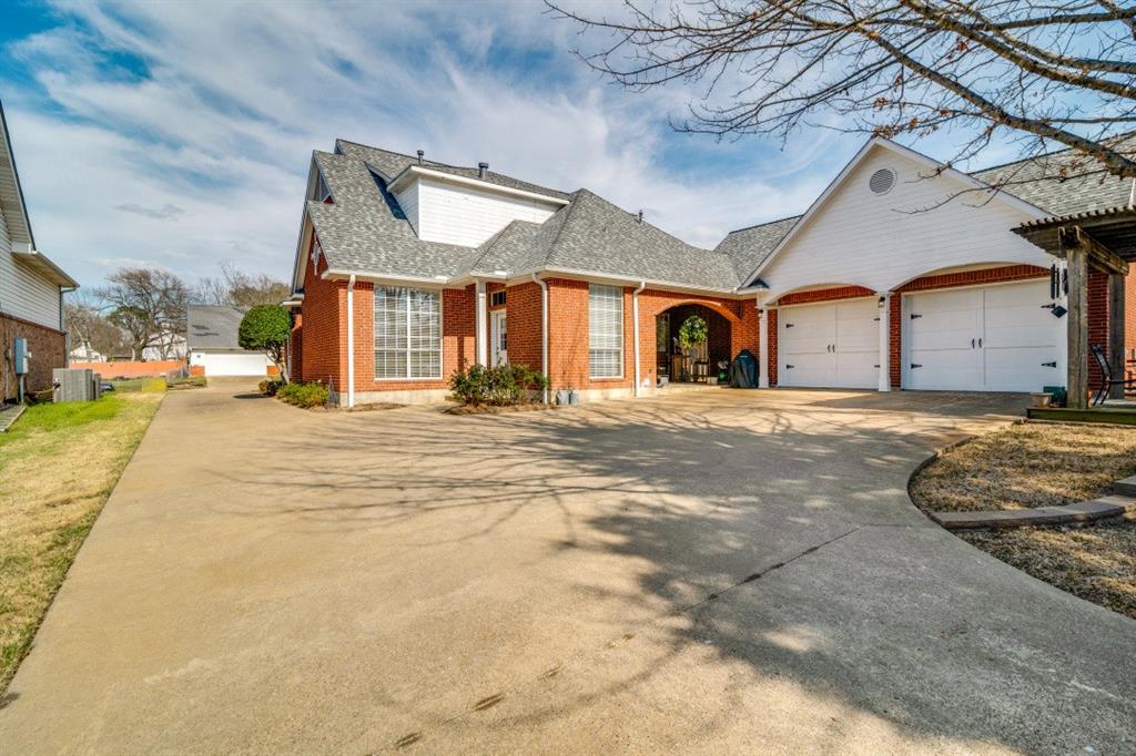 8 Griffith Court Terrell, TX 75160 - Photo 25 of 25 View of back of property featuring driveway, roof with shingles, brick siding, and an attached garage