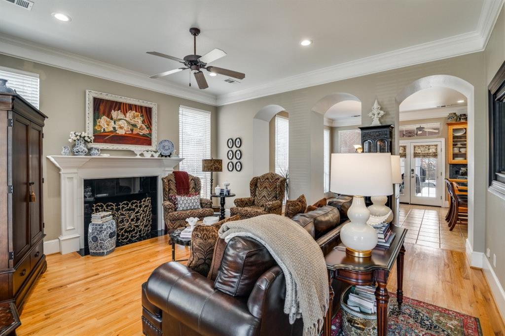 8 Griffith Court Terrell, TX 75160 - Photo 5 of 25 Living room featuring ceiling fan, a gas fireplace, crown molding, light hardwood floors, and arched walkways