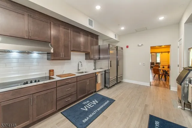 a kitchen with stainless steel appliances granite countertop a sink stove and cabinets