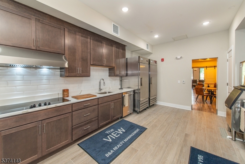 10 Kingsbridge Road, Unit 207 Fairfield, NJ 07004 - Photo 13 of 15 a kitchen with stainless steel appliances granite countertop a sink stove and cabinets