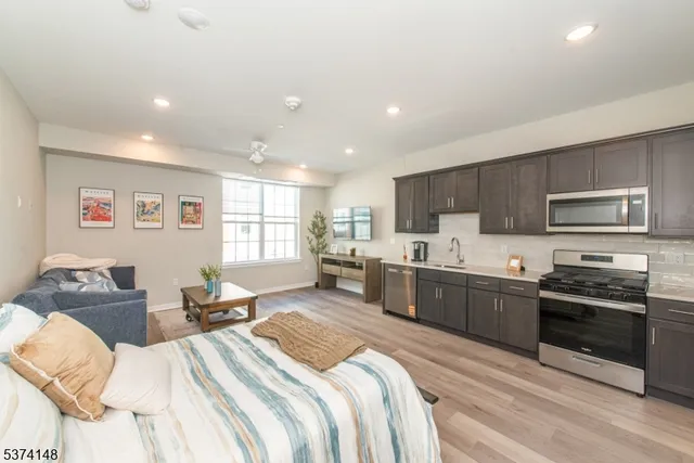 a large bedroom with a bed and a view of kitchen