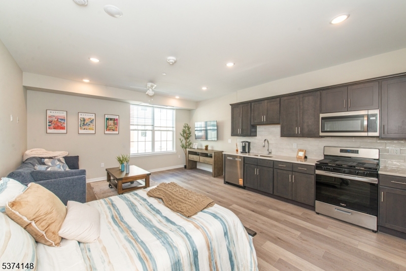 10 Kingsbridge Road, Unit 207 Fairfield, NJ 07004 - Photo 2 of 15 a large bedroom with a bed and a view of kitchen