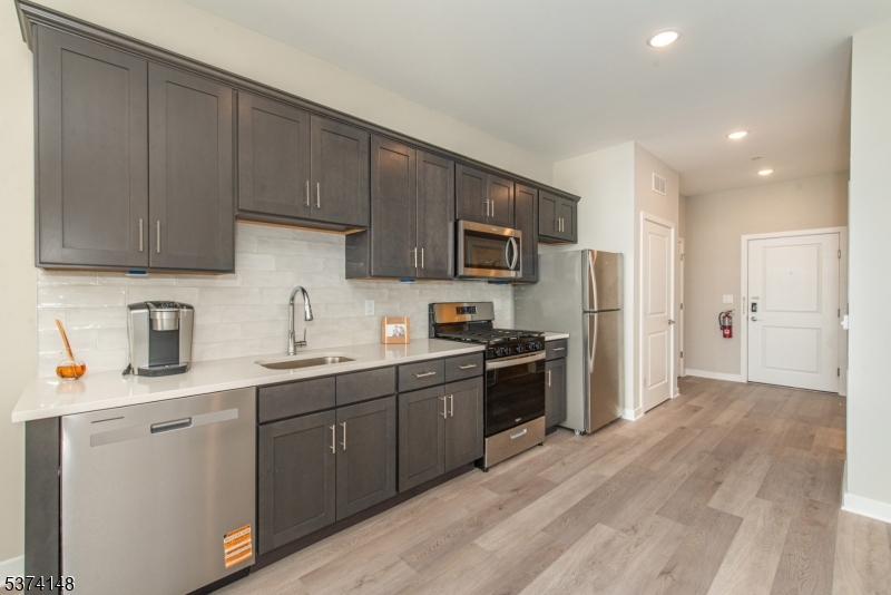 10 Kingsbridge Road, Unit 207 Fairfield, NJ 07004 - Photo 4 of 15 a kitchen with stainless steel appliances granite countertop a refrigerator stove top oven a sink and dishwasher