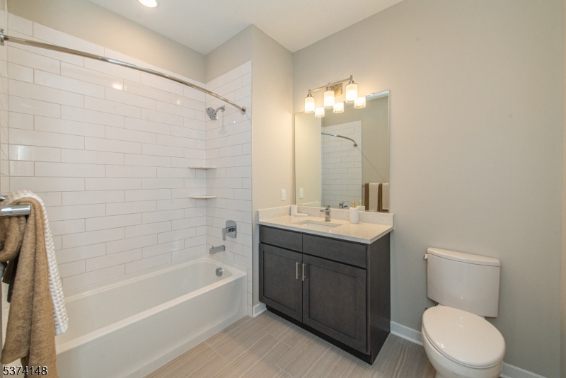 10 Kingsbridge Road, Unit 207 Fairfield, NJ 07004 - Photo 8 of 15 a bathroom with a toilet sink and mirror