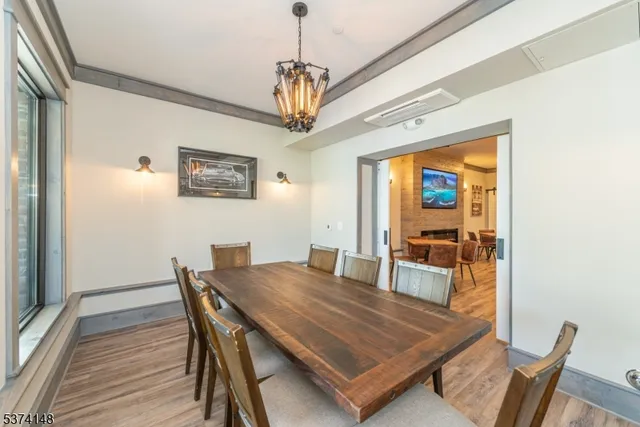 a dining room with furniture a chandelier and wooden floor