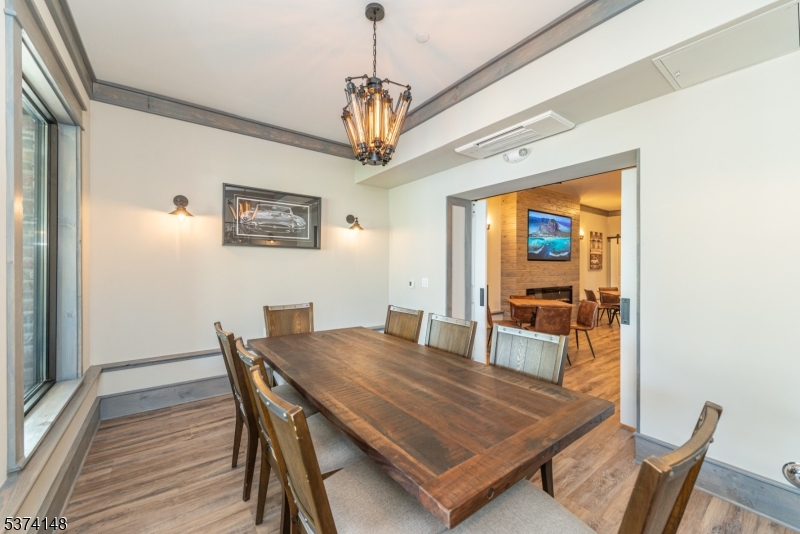 10 Kingsbridge Road, Unit 207 Fairfield, NJ 07004 - Photo 10 of 15 a dining room with furniture a chandelier and wooden floor