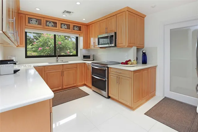 a kitchen with stainless steel appliances granite countertop a stove a sink and a microwave